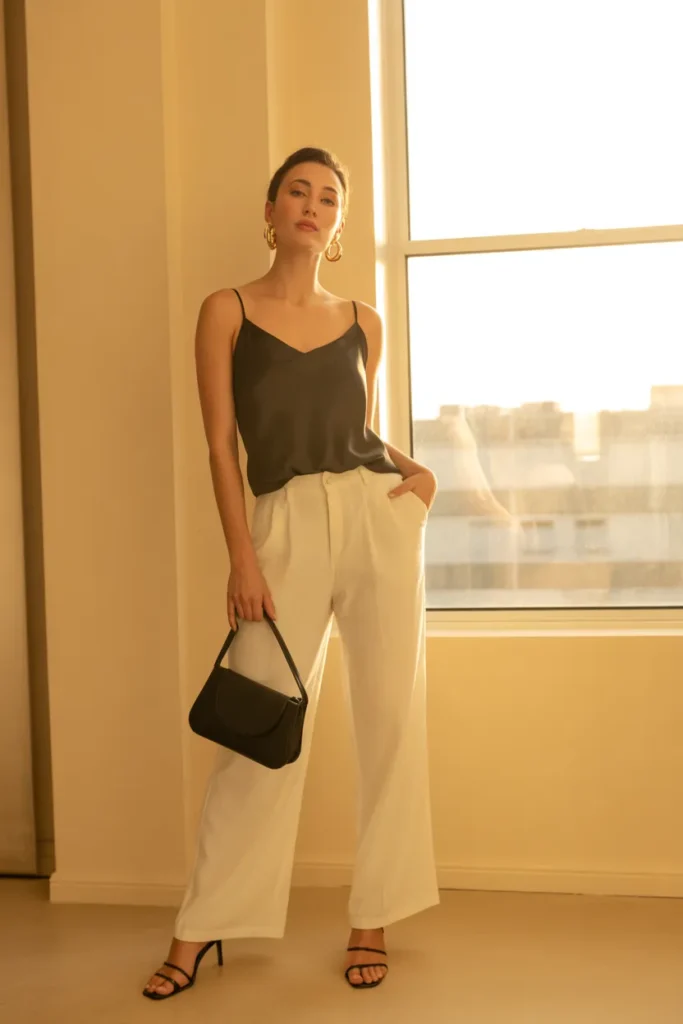 Cream linen pants date night outfit with black silk camisole and gold jewelry