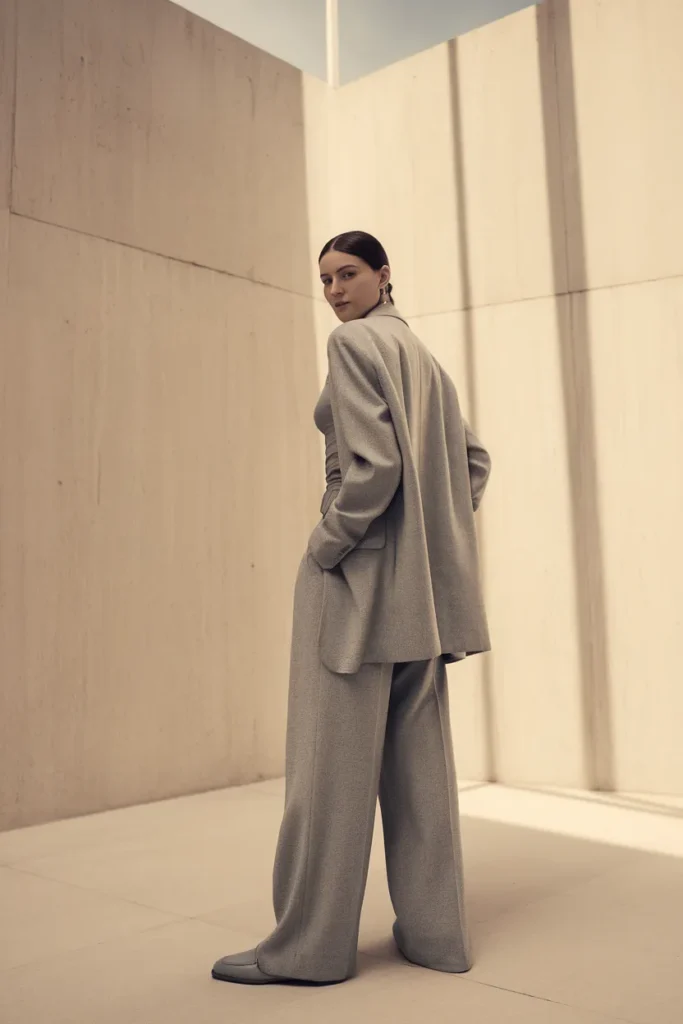 Woman in gray monochrome blazer and wide-leg trousers showing balanced proportion