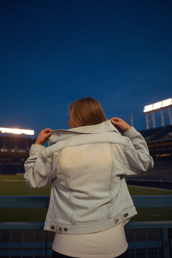 Denim jacket layered over a white tee for a night baseball game outfit