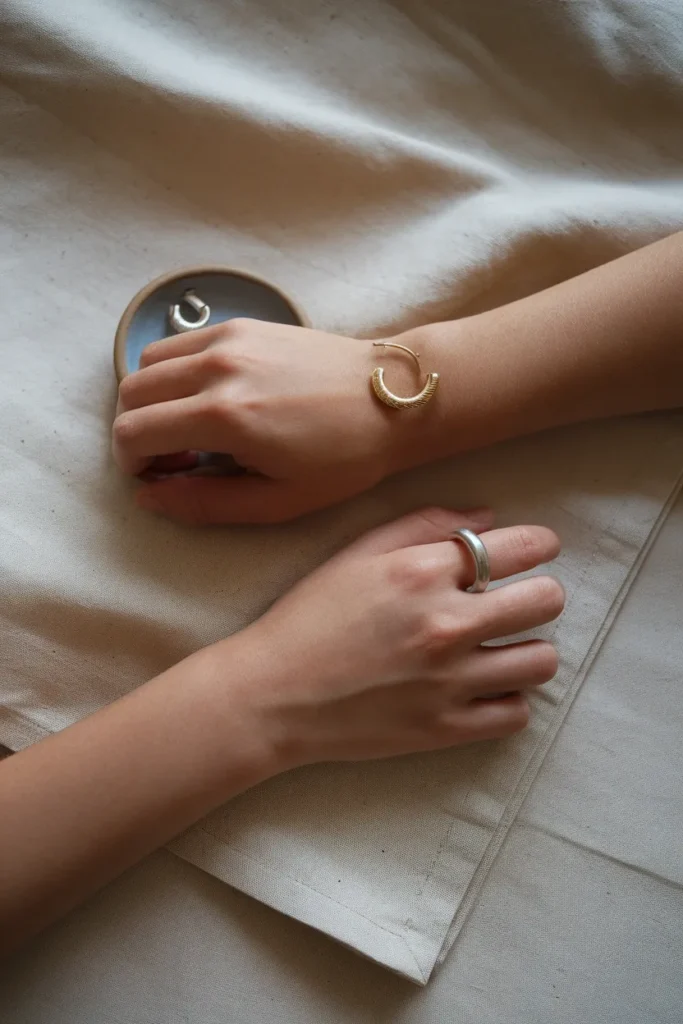 Gold and silver jewelry compared side by side against skin to find warm or cool undertone.